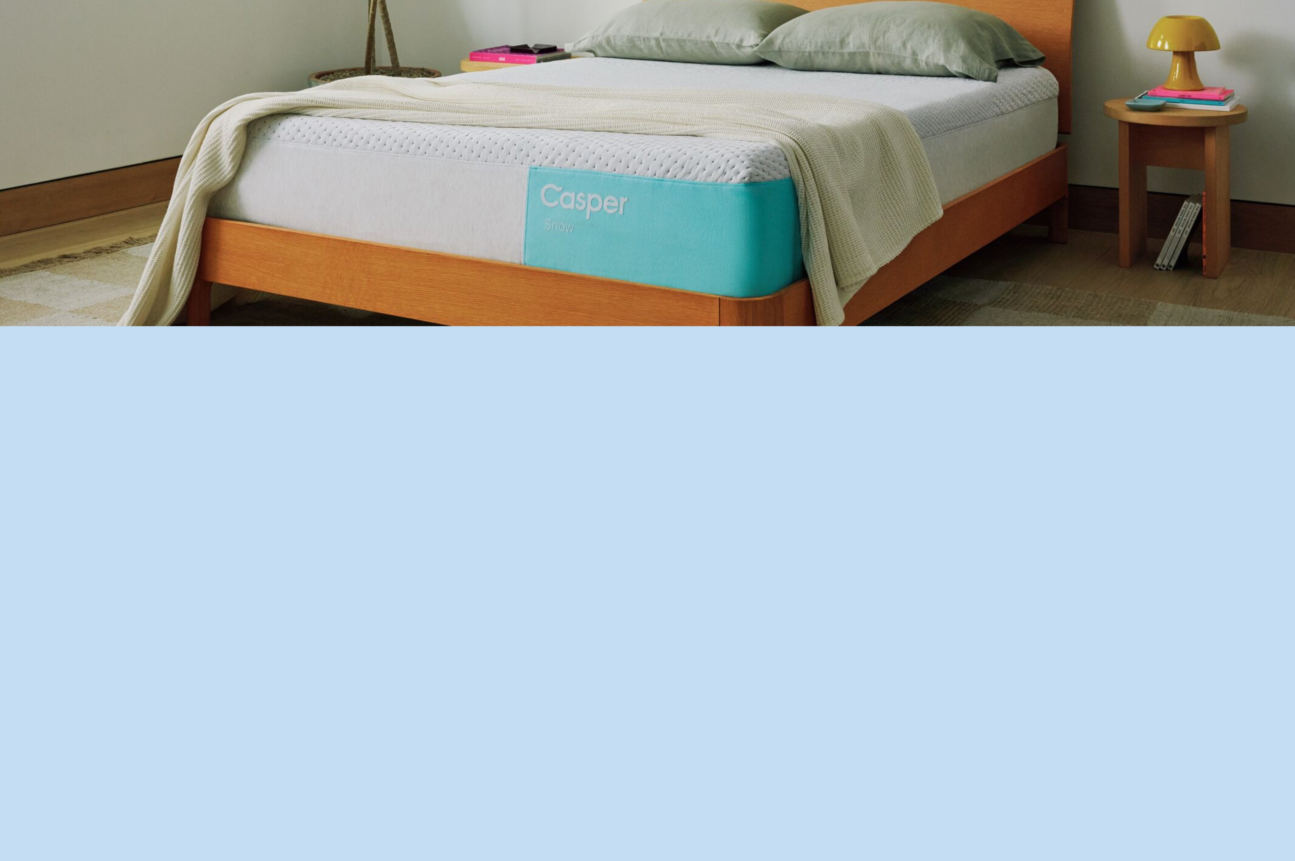 Image of a Casper Snow mattress on a bed against a light blue background.