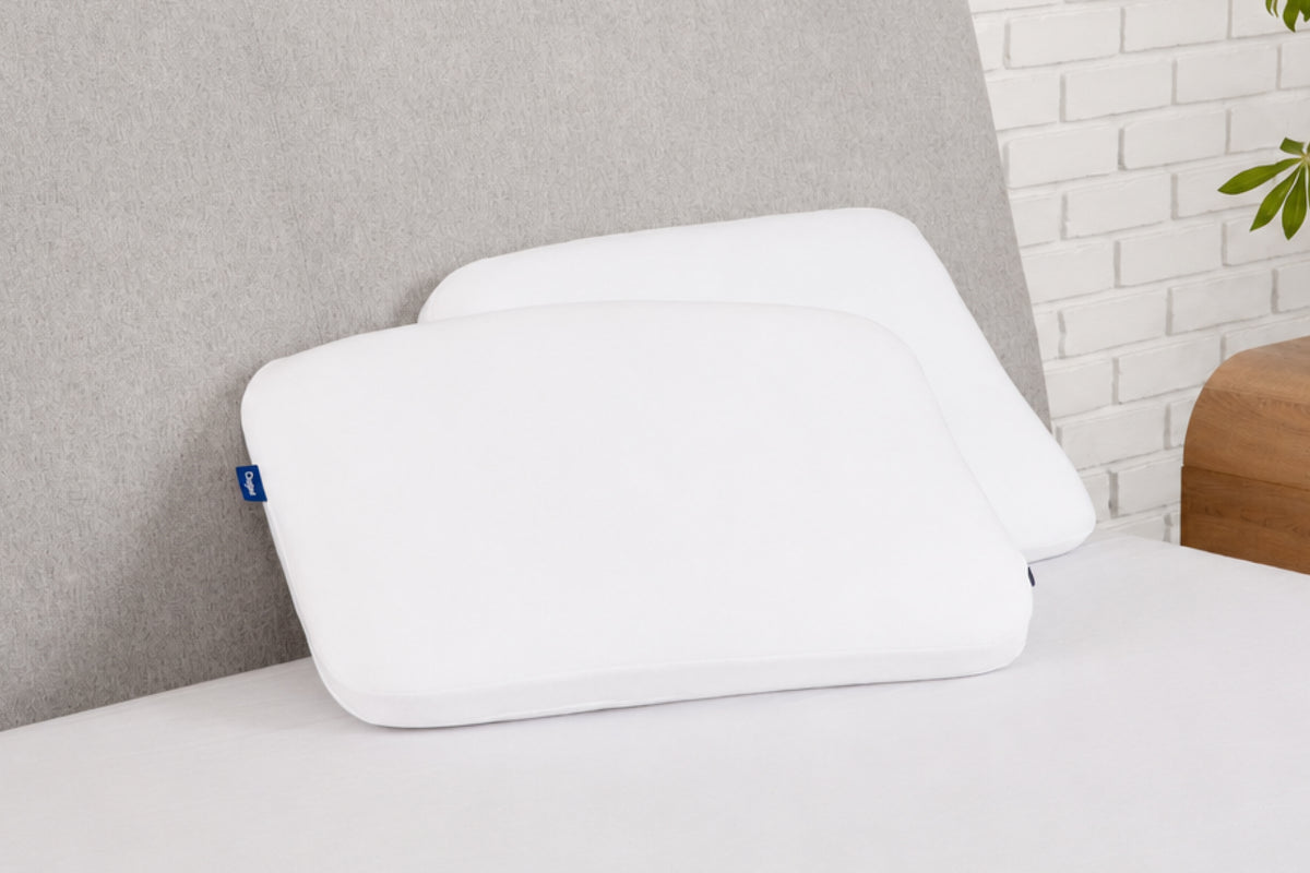 Casper's Foam Snow Pillow Double Pack leaning against a headboard
