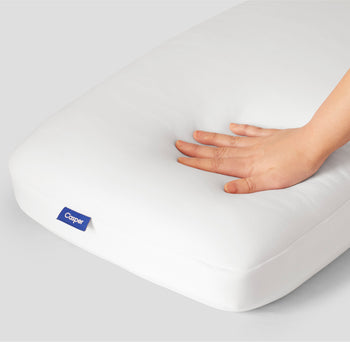 A hand feeling the Casper Foam Pillow with Snow Technology