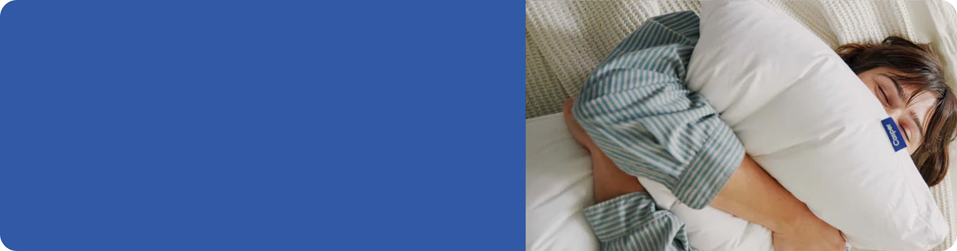 A person lying in bed squeezing a pillow