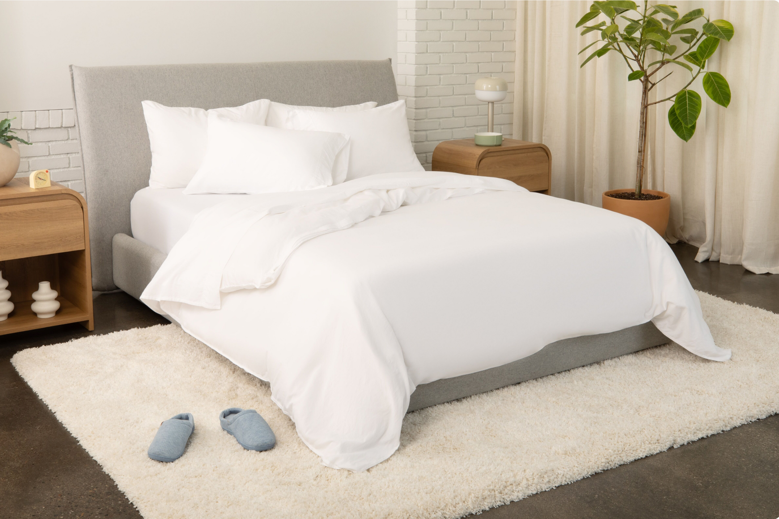 Haven Bed Frame, gray, full view of the bed frame in a bed room with a dressed mattress on it.