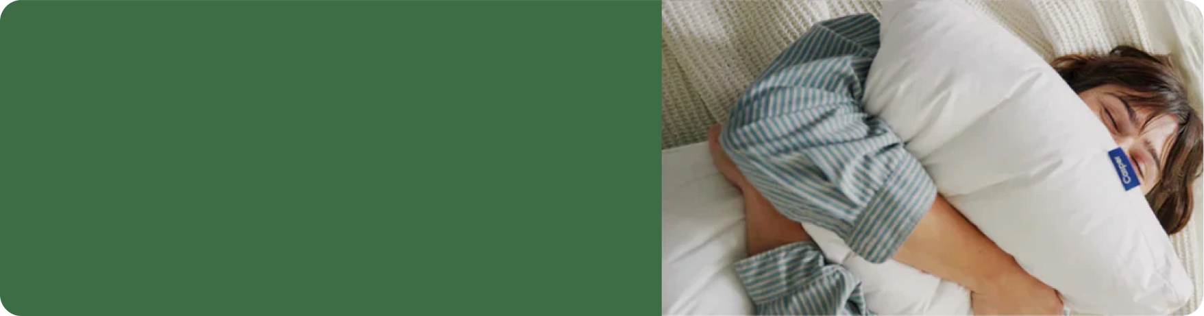 A person lying in bed squeezing a pillow