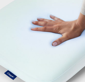 A hand feeling the Hybrid Pillow with Snow Technology.