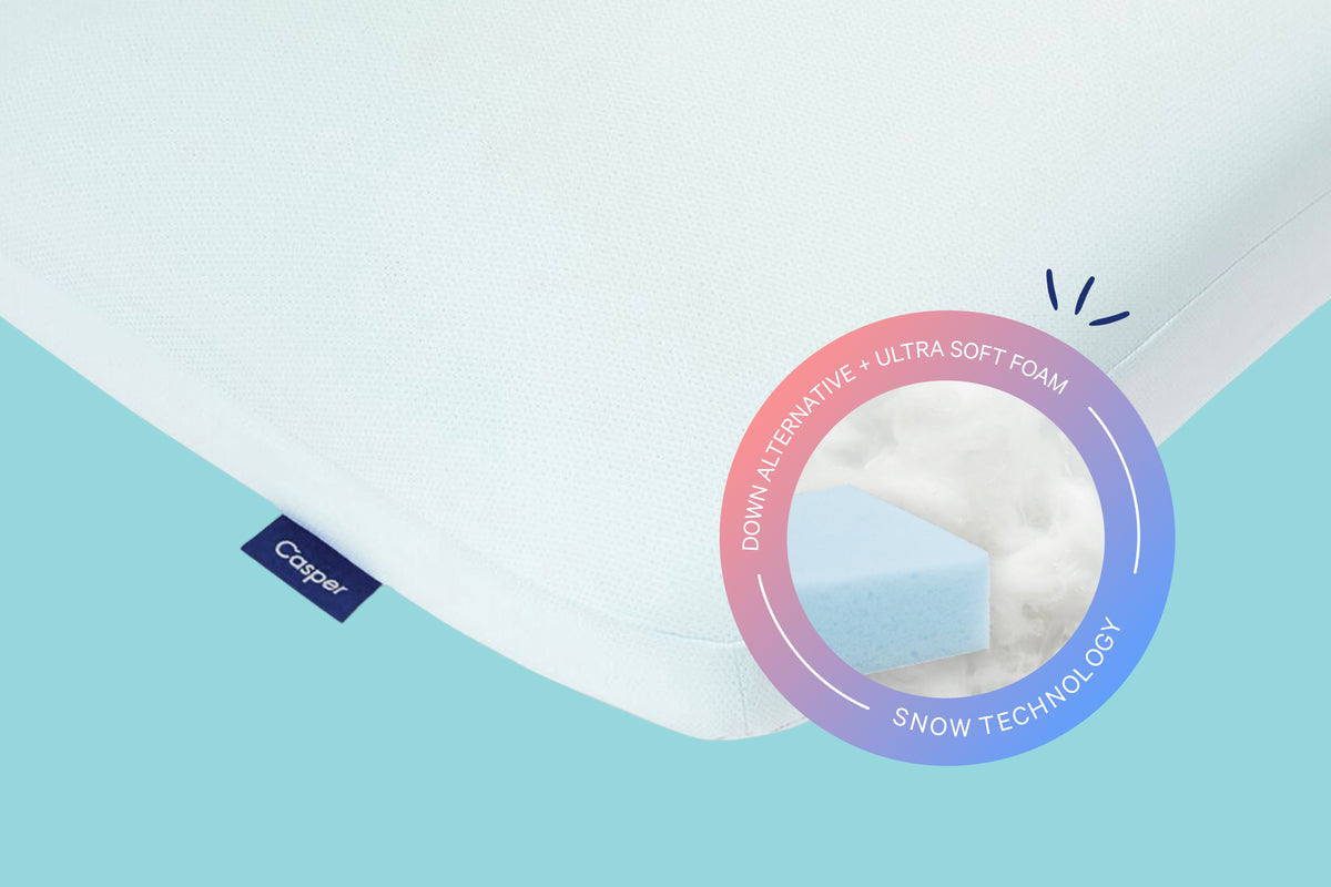 Close-up of the Hybrid Snow Pillow against a light turquoise background. A badge on the image indicates that it has down-alternative fill and ultra soft foam with Snow Technology™.