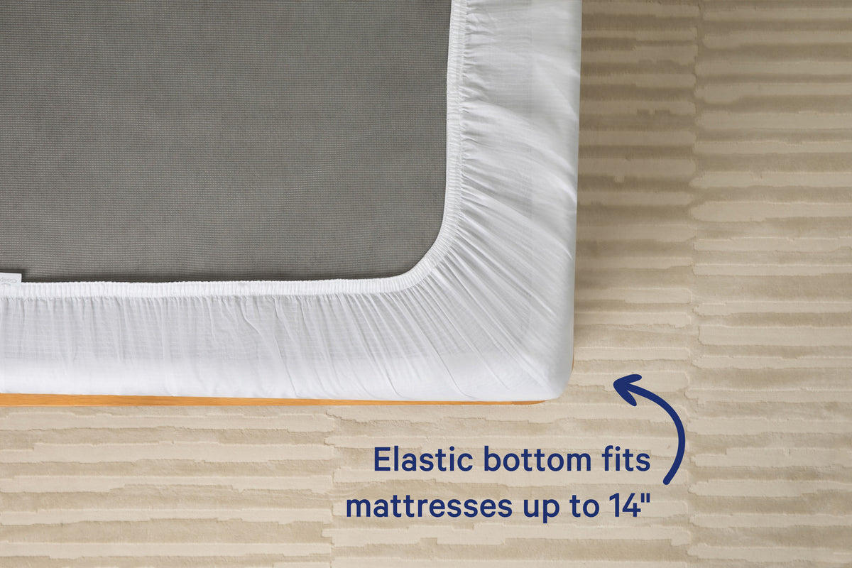 Underside view of a mattress with a white fitted sheet. Text on the image reads 'Elastic bottom fits mattresses up to 14 inches.'