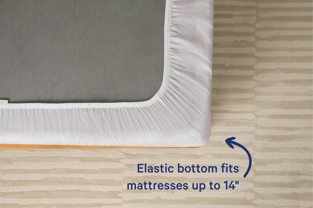 Underside view of a mattress with a white fitted sheet. Text on the image reads 'Elastic bottom fits mattresses up to 14 inches.'