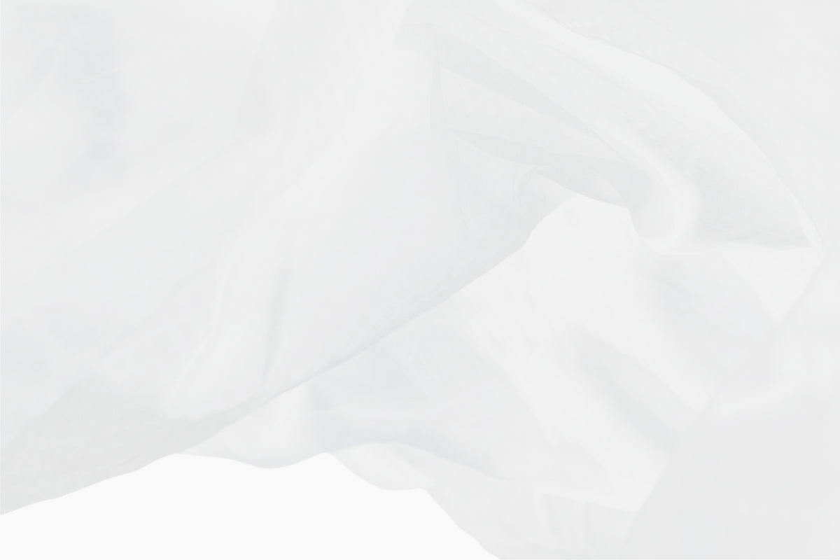 A still shot of a white bed sheet being tossed in the air against a white background