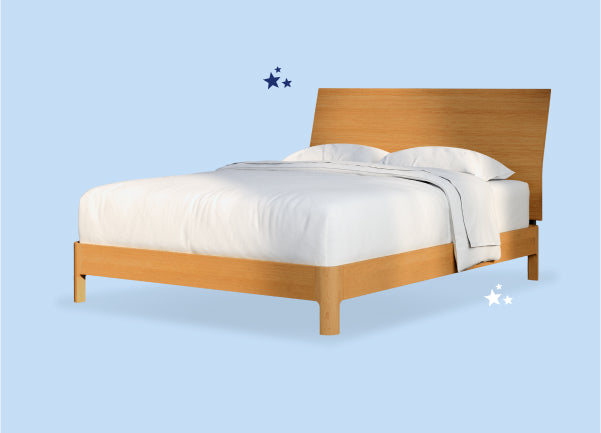 A made bed with two pillows on a wooden bed frame against a light blue background