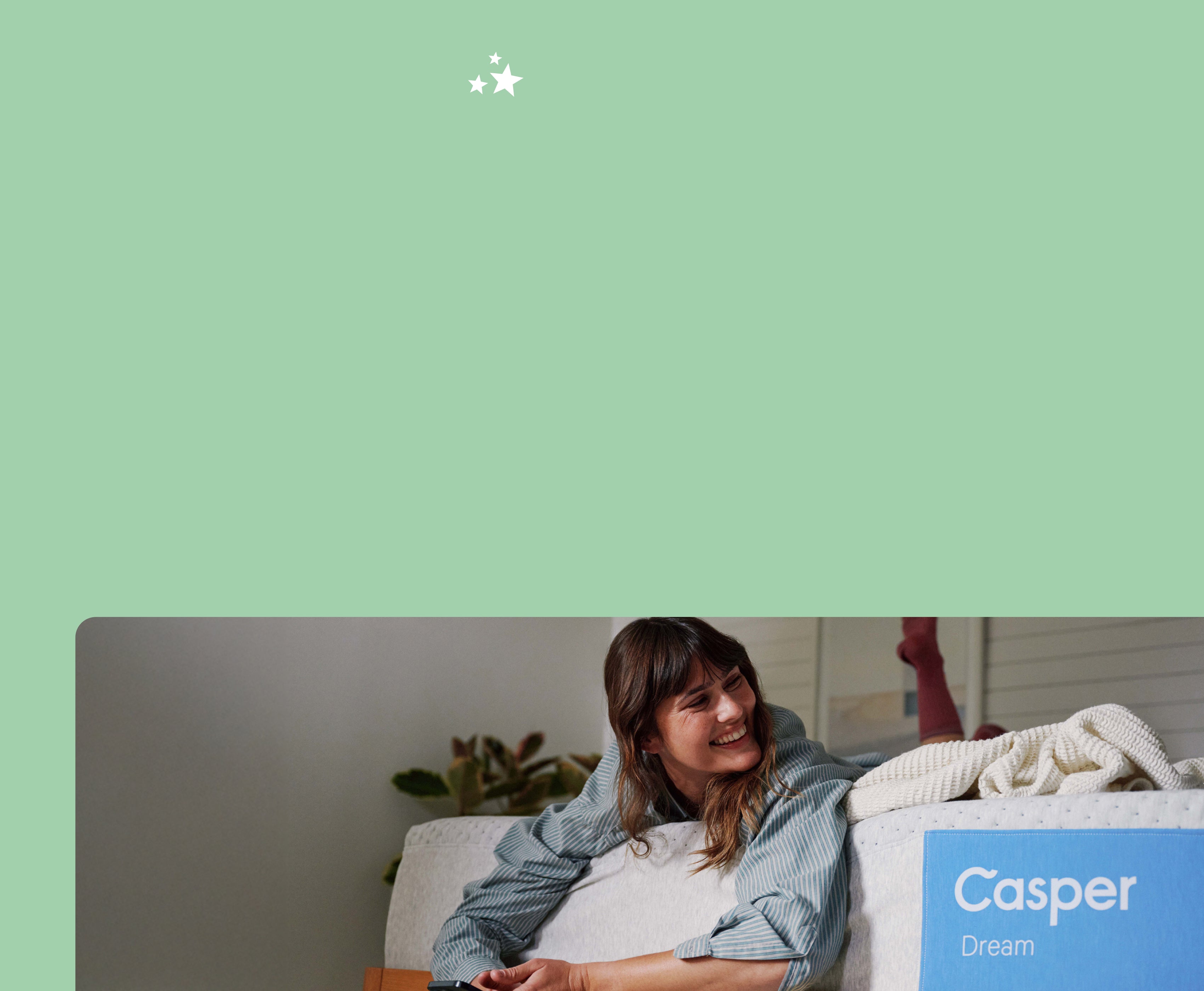 A woman lies over the edge of her Casper Dream mattress.