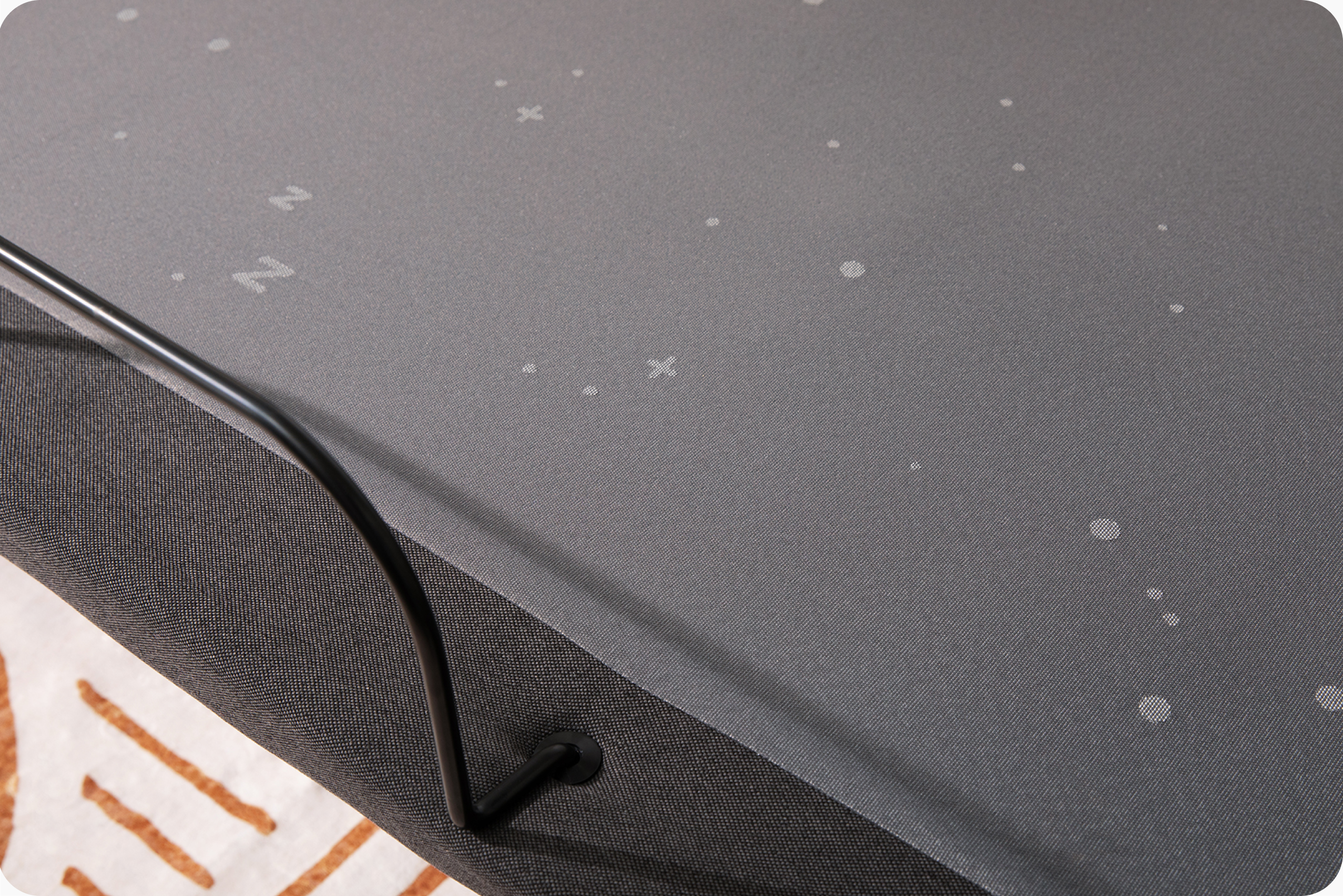 Close-up of a dark gray fabric surface with small white star-like specks