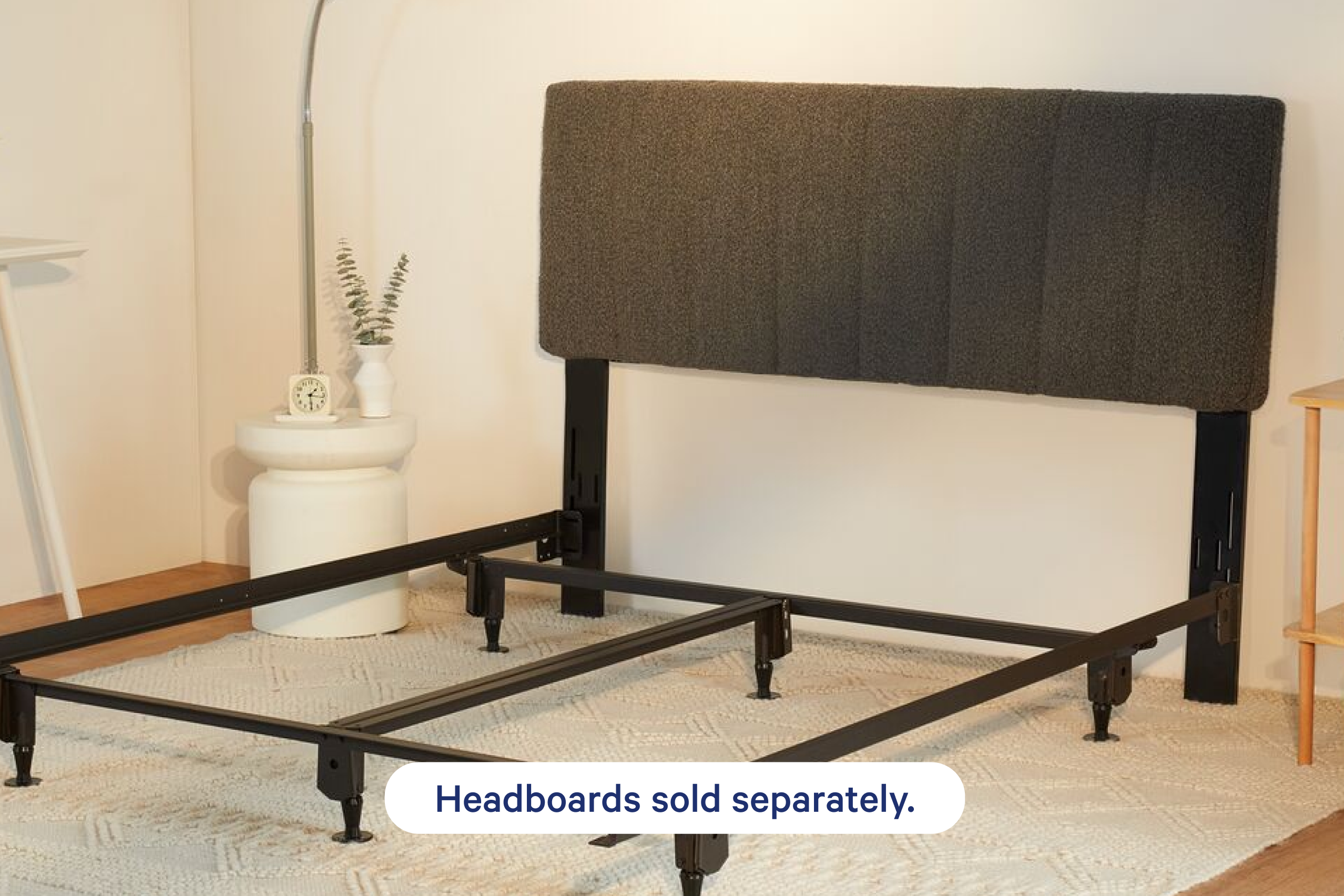 A black metal bed frame connected to an upholstery headboard. A text overlay at the bottom says "Headboards sold separately."