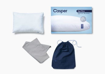 Casper Nap Pillow with packaging, drawstring carrying case, and pillowcase against a white background