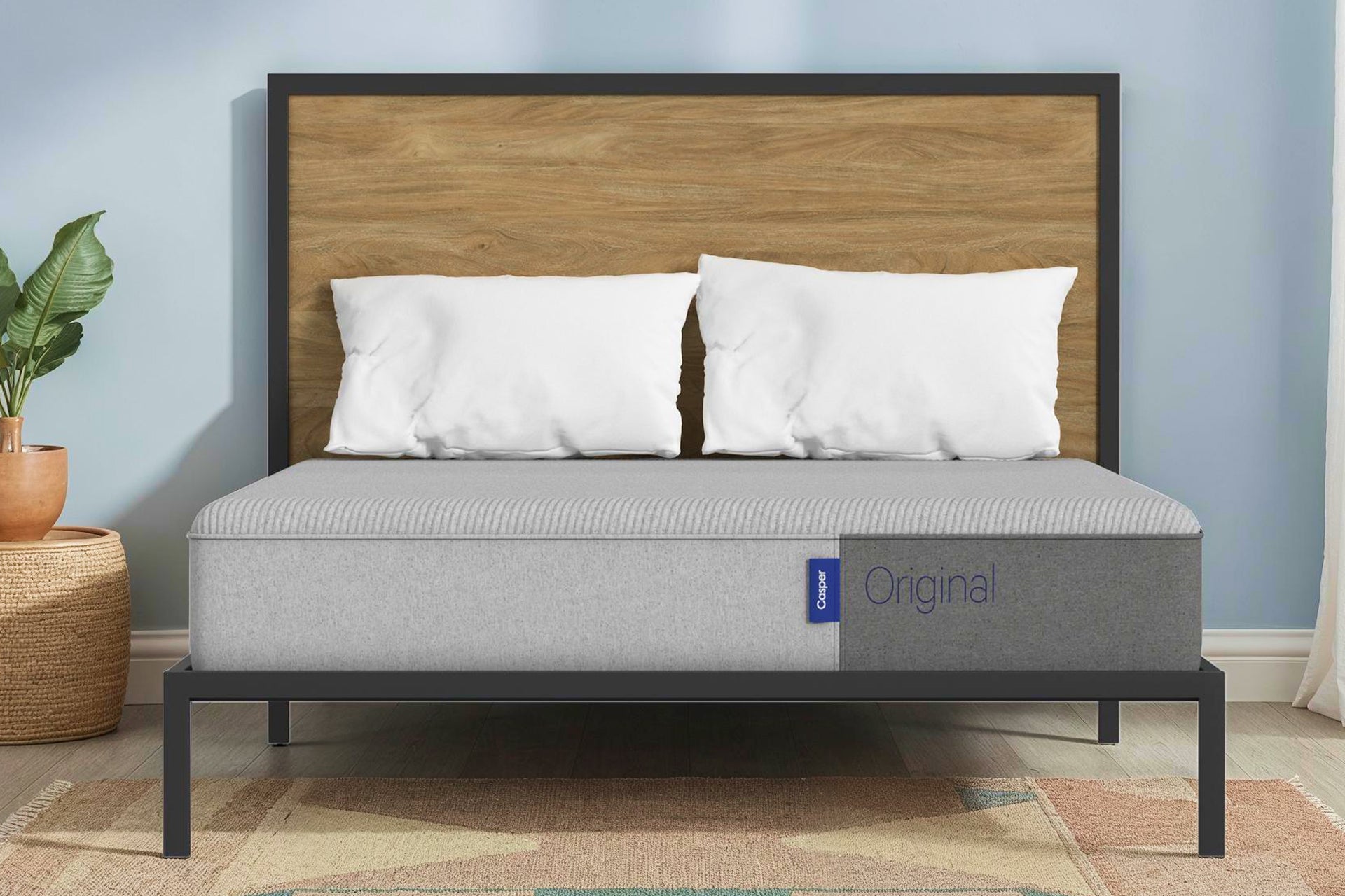 The Casper Original mattress on a metal bed frame with a wooden headboard.