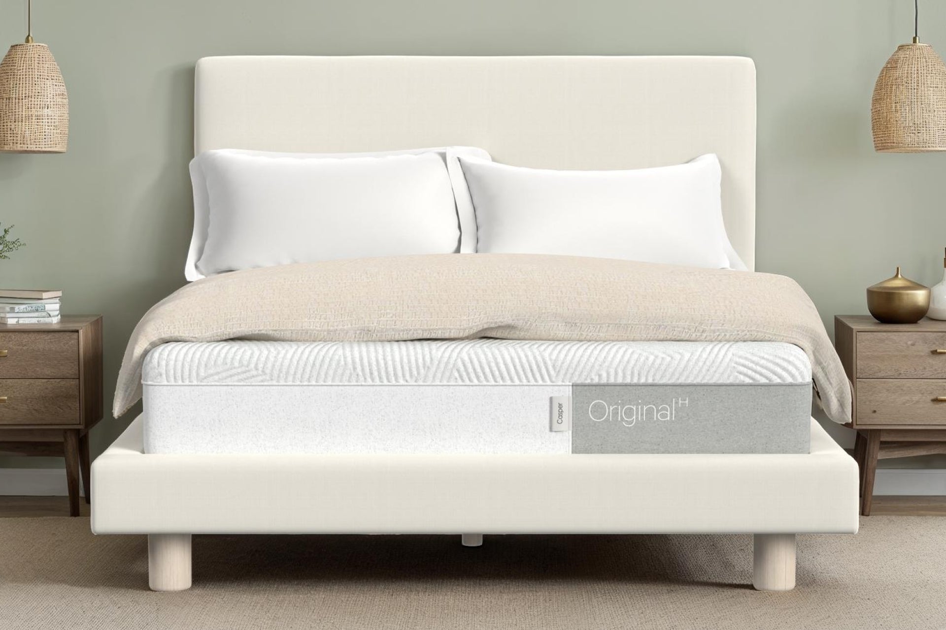 Casper's Original Hybrid mattress on a fabric bed frame with a headboard in a light colored room with modern decor