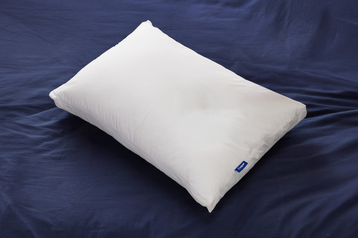 Casper's Original Pillow on a mattress with navy blue sheets