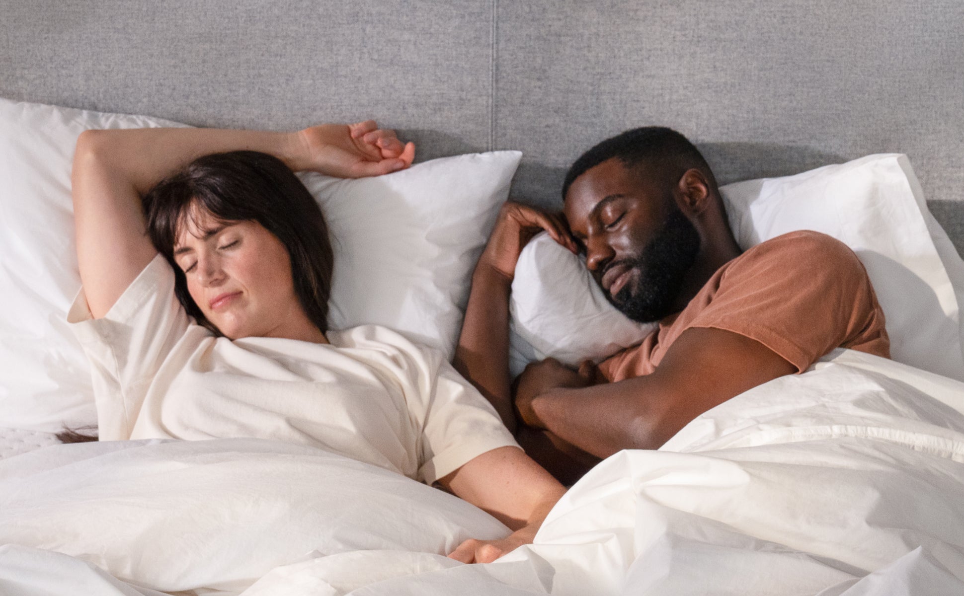 A couple sleeping on two Casper Original Pillows in bed.