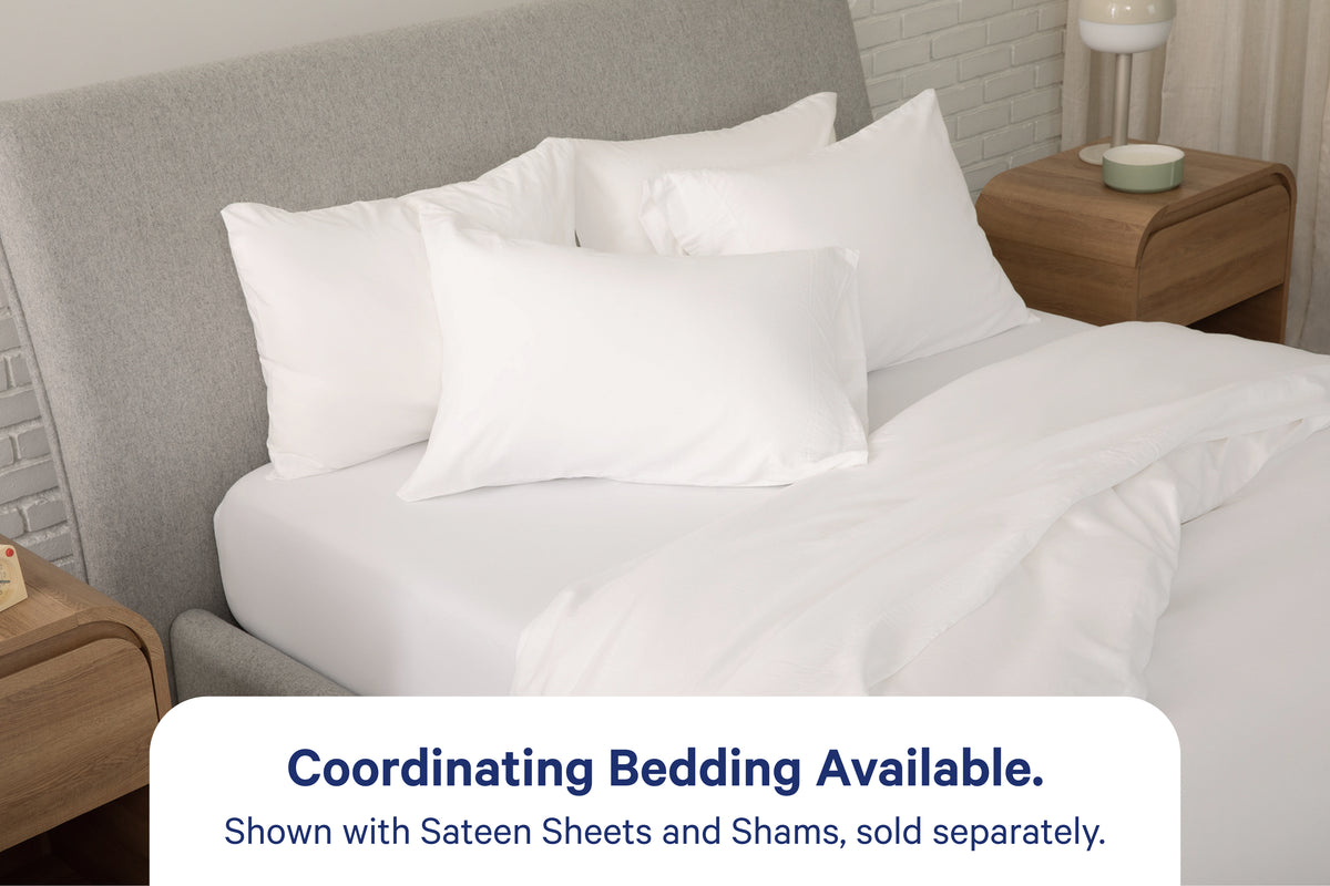 A fully dressed bed with white bedding. An overlay on the image with text reads 'Coordinating Bedding Available. Shown with Percale Sheets and Shams, sold separately.'