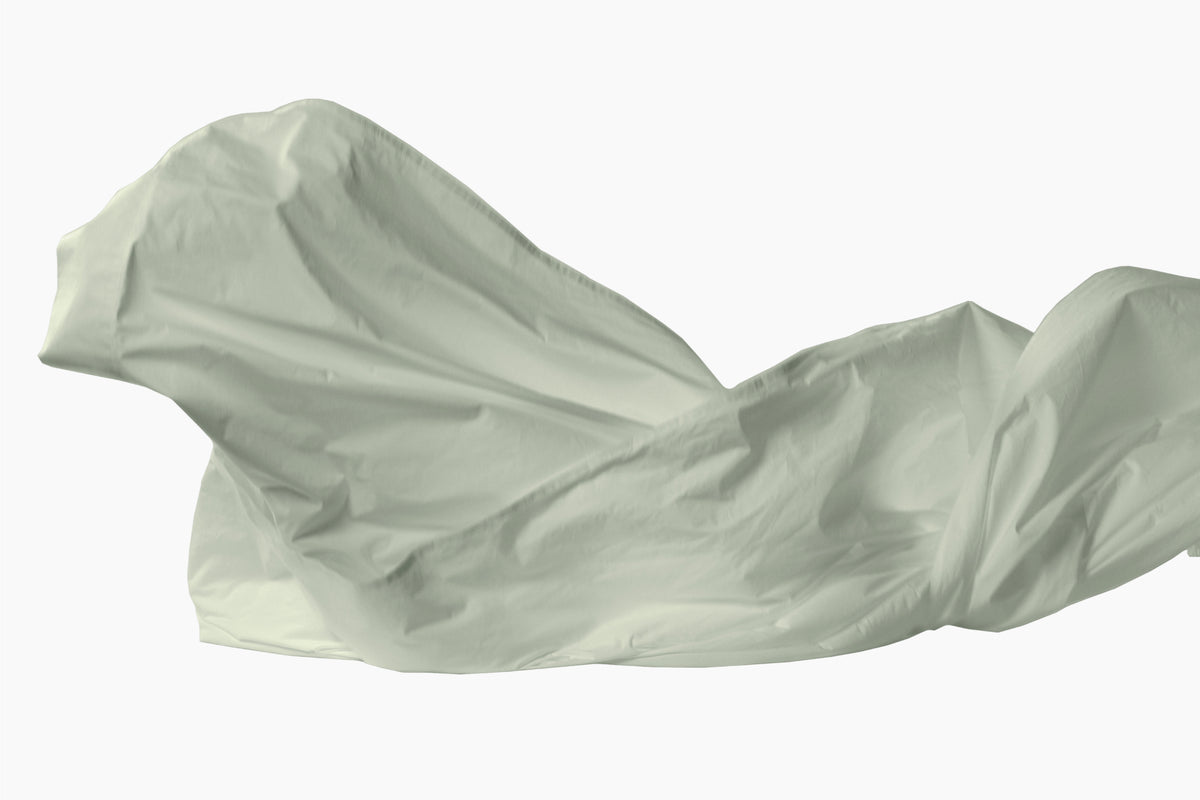 A eucalyptus-green draped Percale sheet, shown as a crumpled or flowing sheet against a plain white background