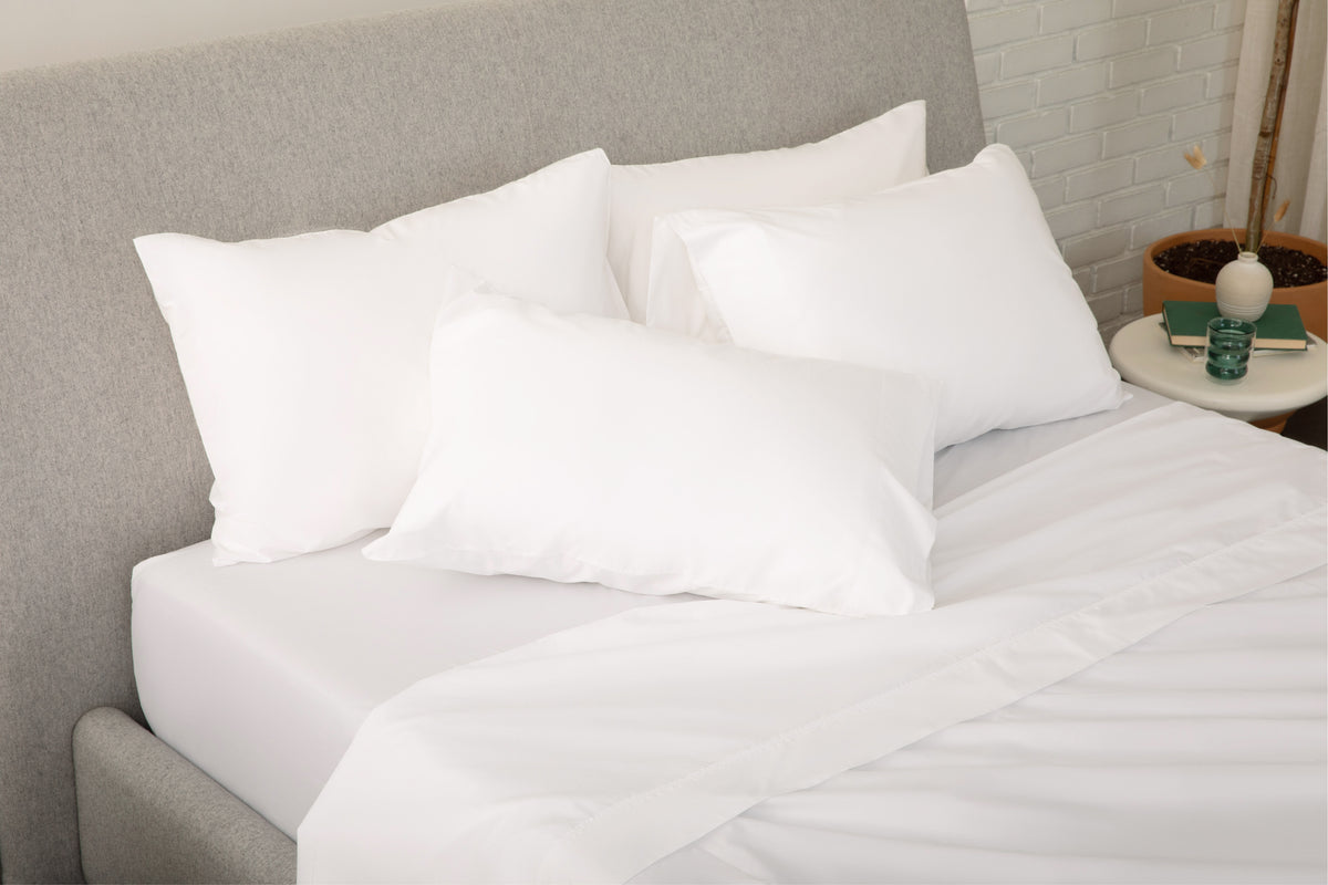 A fully dressed bed with white bedding