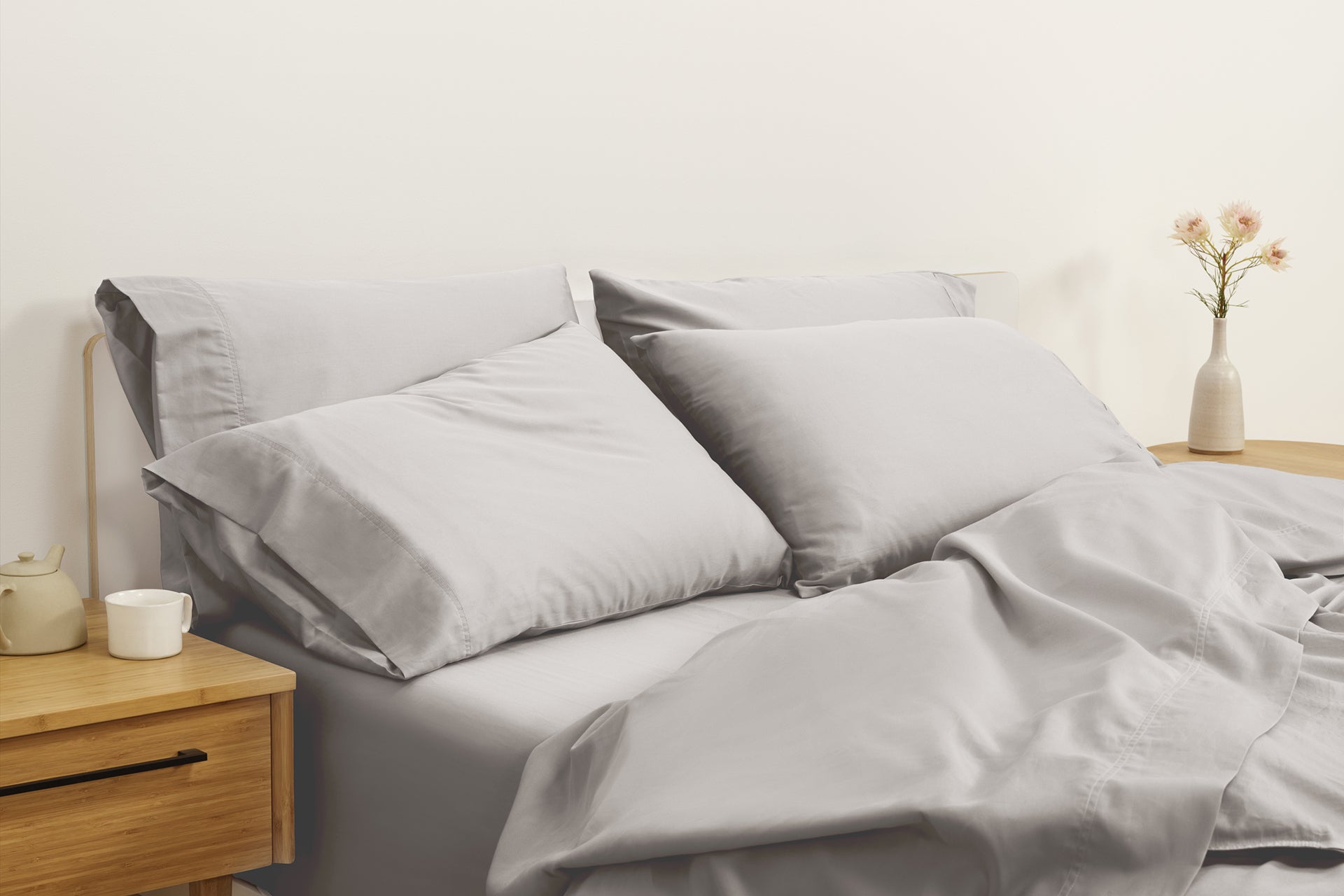 A mattress with pillows and a gray, Percale sheet set