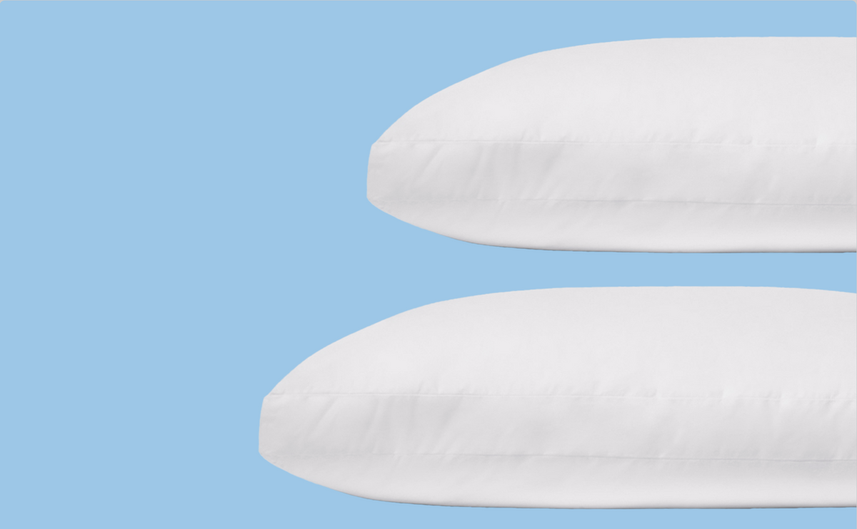 A cropped view of a standard size pillow stacked above a king size pillow for scale
