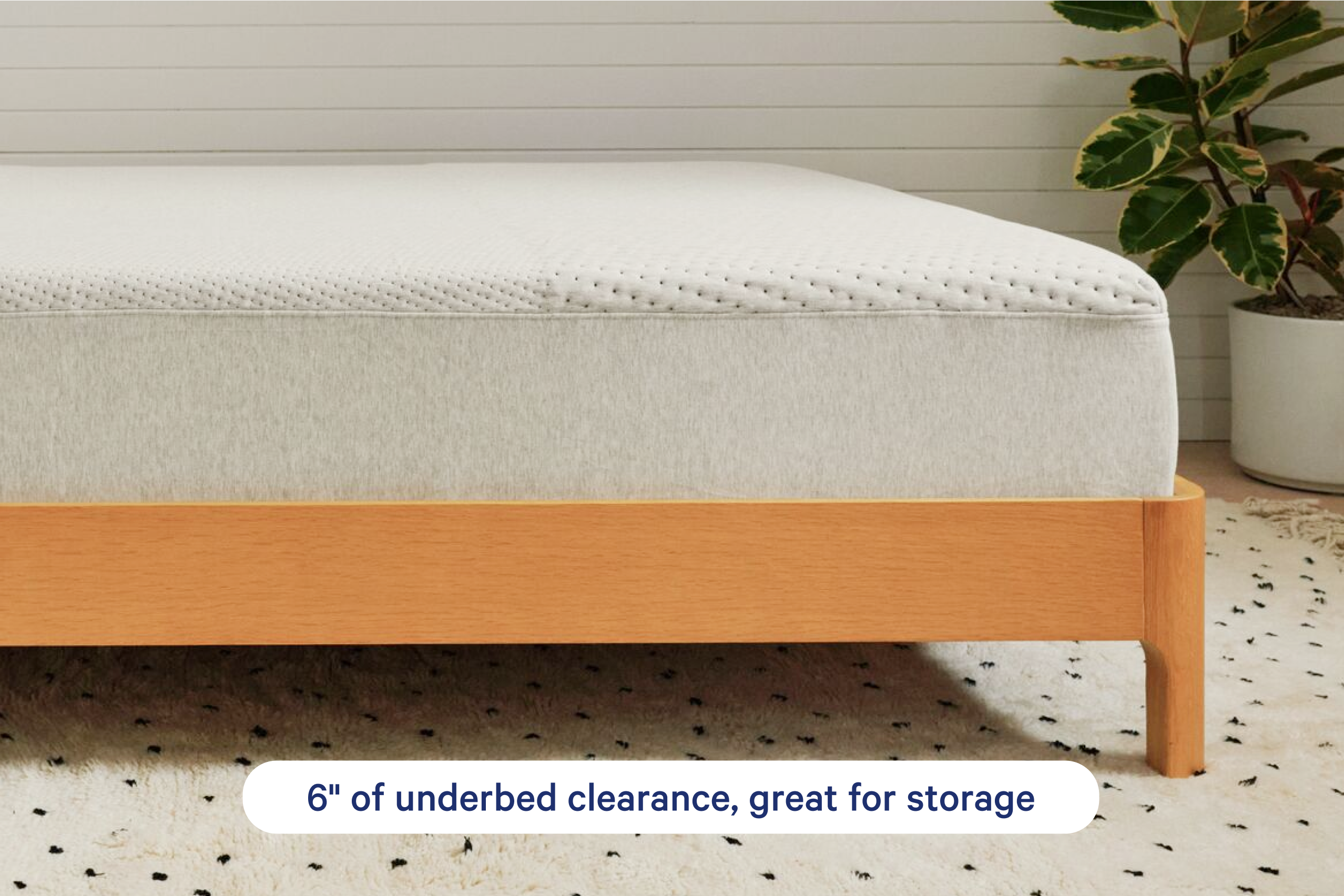 A close-up of a wooden bed frame with a mattress or bedding surface shown from below, highlighting 6 inches of underbed clearance. Text at the bottom reads '6" of underbed clearance, great for storage.'