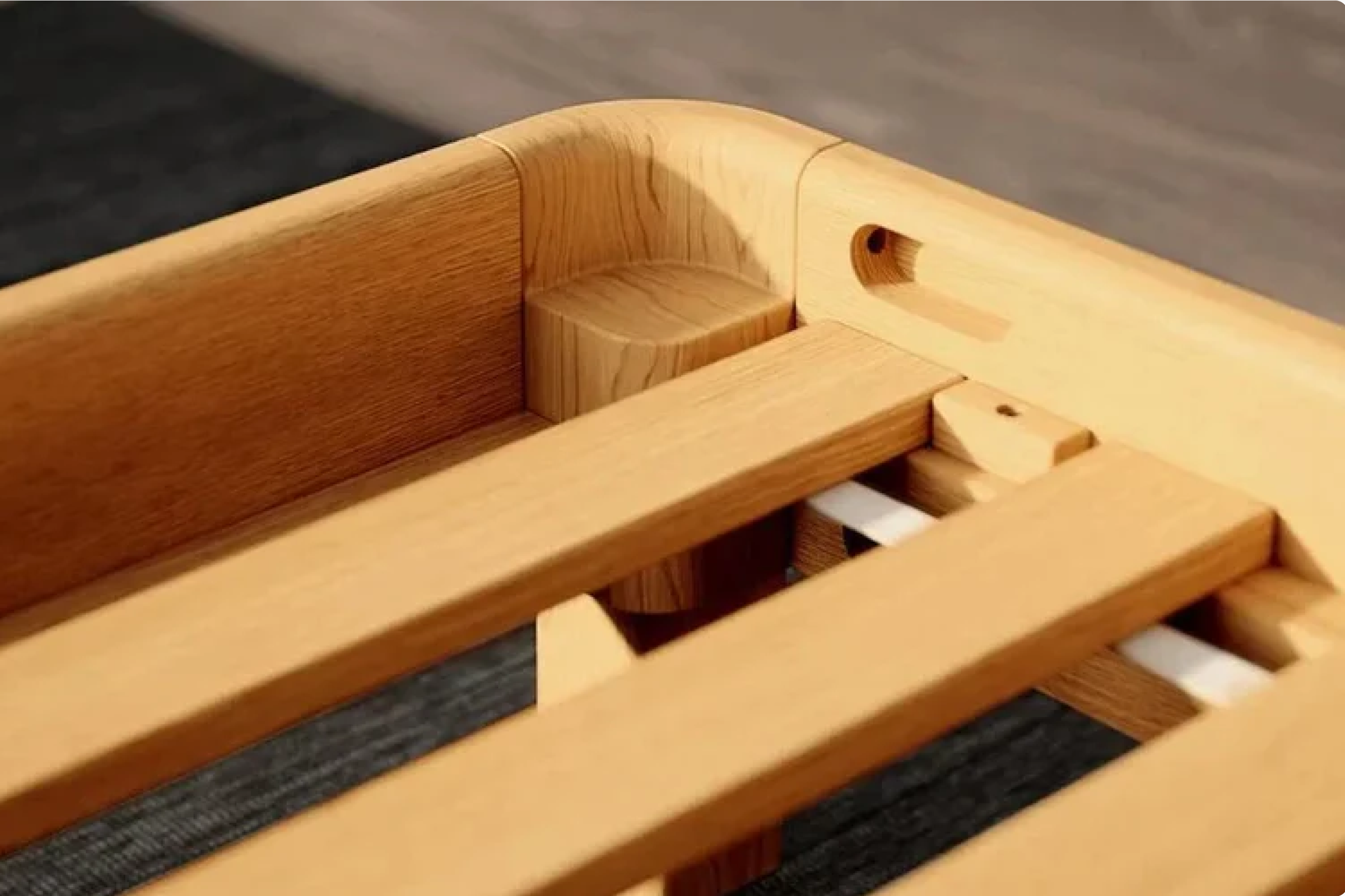 Close-up of a natural wooden bed frame corner with slats and a visible peg-lock joint, photographed indoors on a dark rug.
