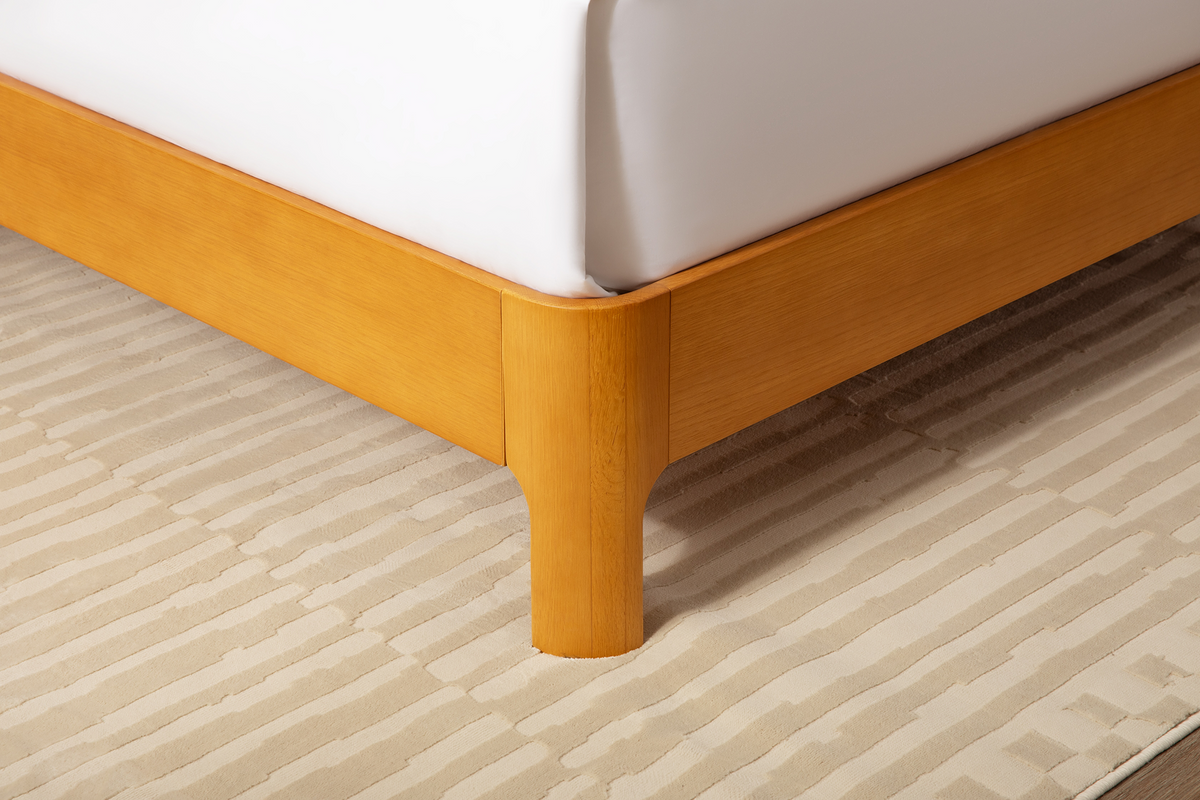close up of corner of Repose Bed Frame, wooden, natural oak, with a curved surface to be soft around the edges.