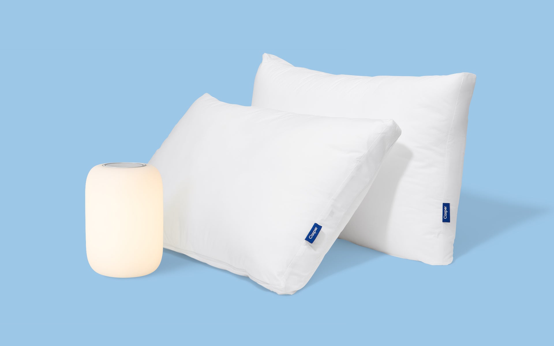 Two Original Pillows and a Glow Light against a blue background