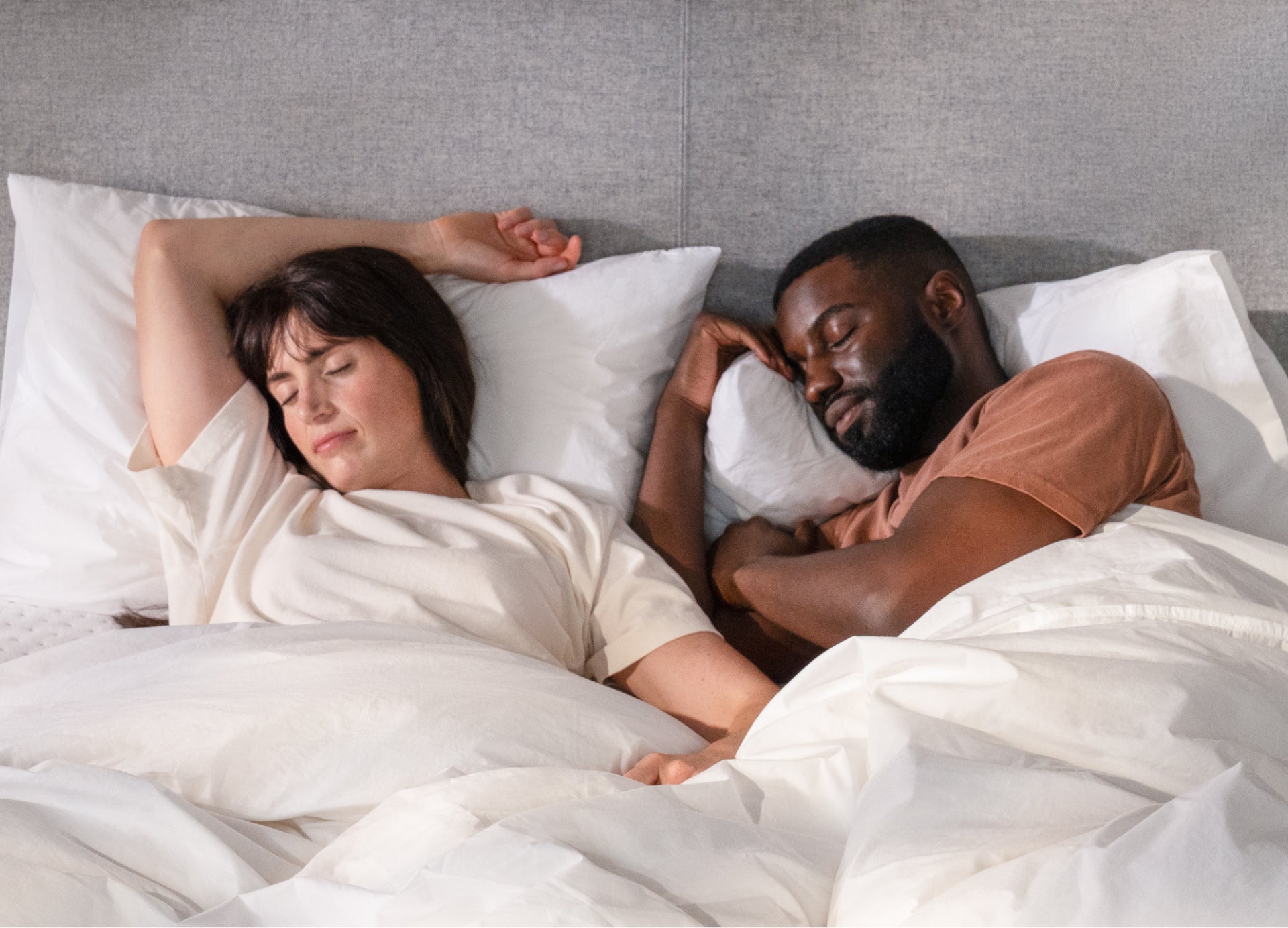 Two people lying in bed together, seemingly sleeping or resting.