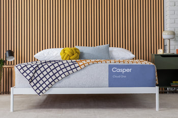 Casper's Cloud One mattress on a bed with a wooden wall and modern decor in the background