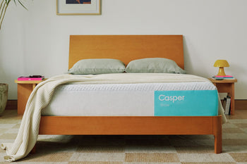 The Casper Snow mattress on a bed in a bedroom with pillows and a blanket on top