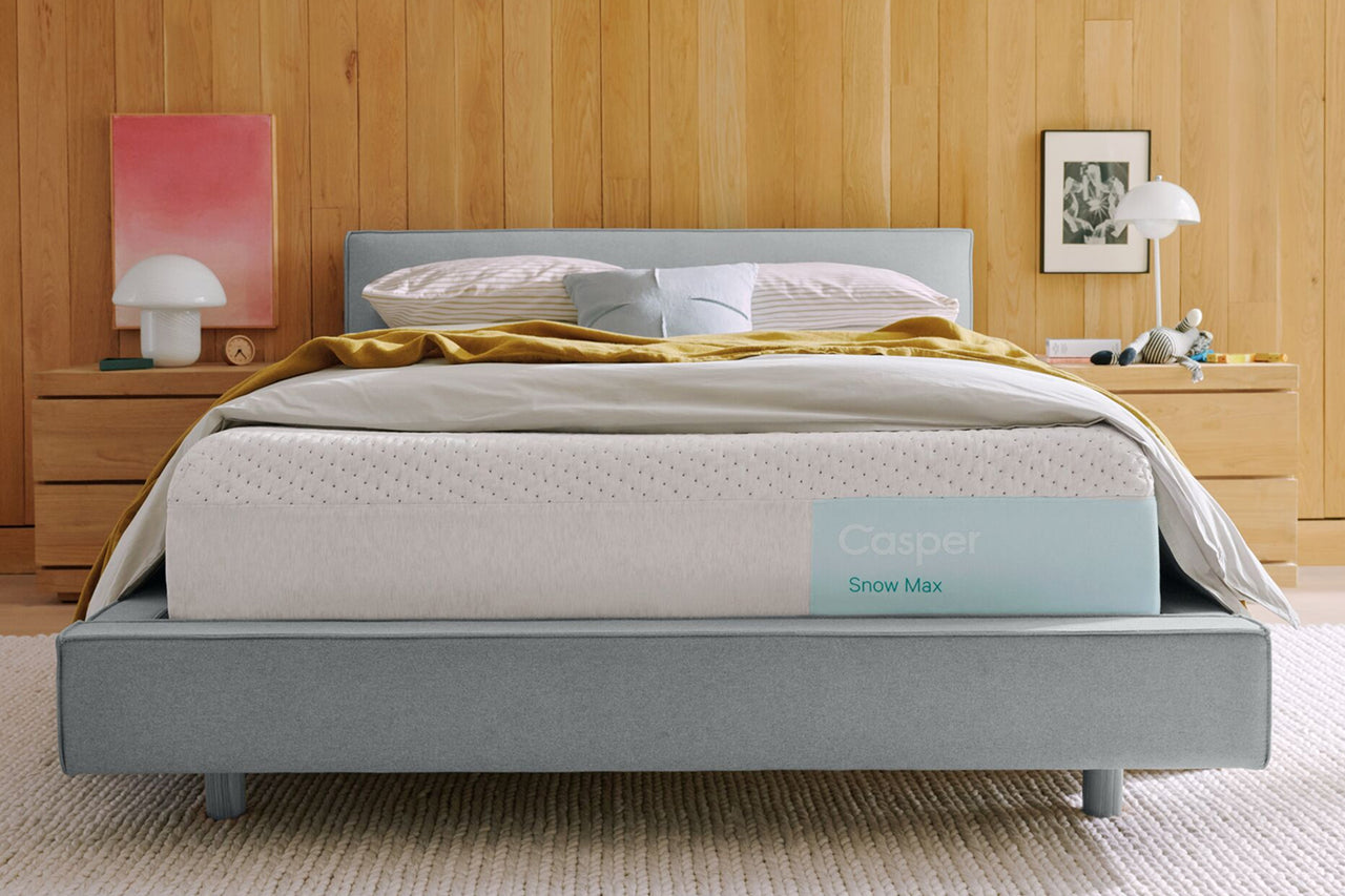 Casper's Snow Max mattress on a bed in a bedroom with pillows and a blanket on top