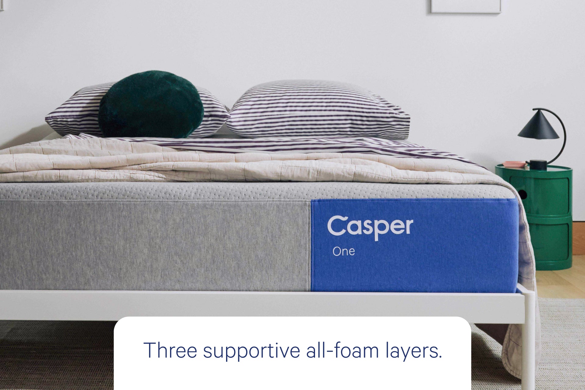 Front view from foot of the bed of Casper's The One mattress. Text on the image says "three supportive all-foam layers."