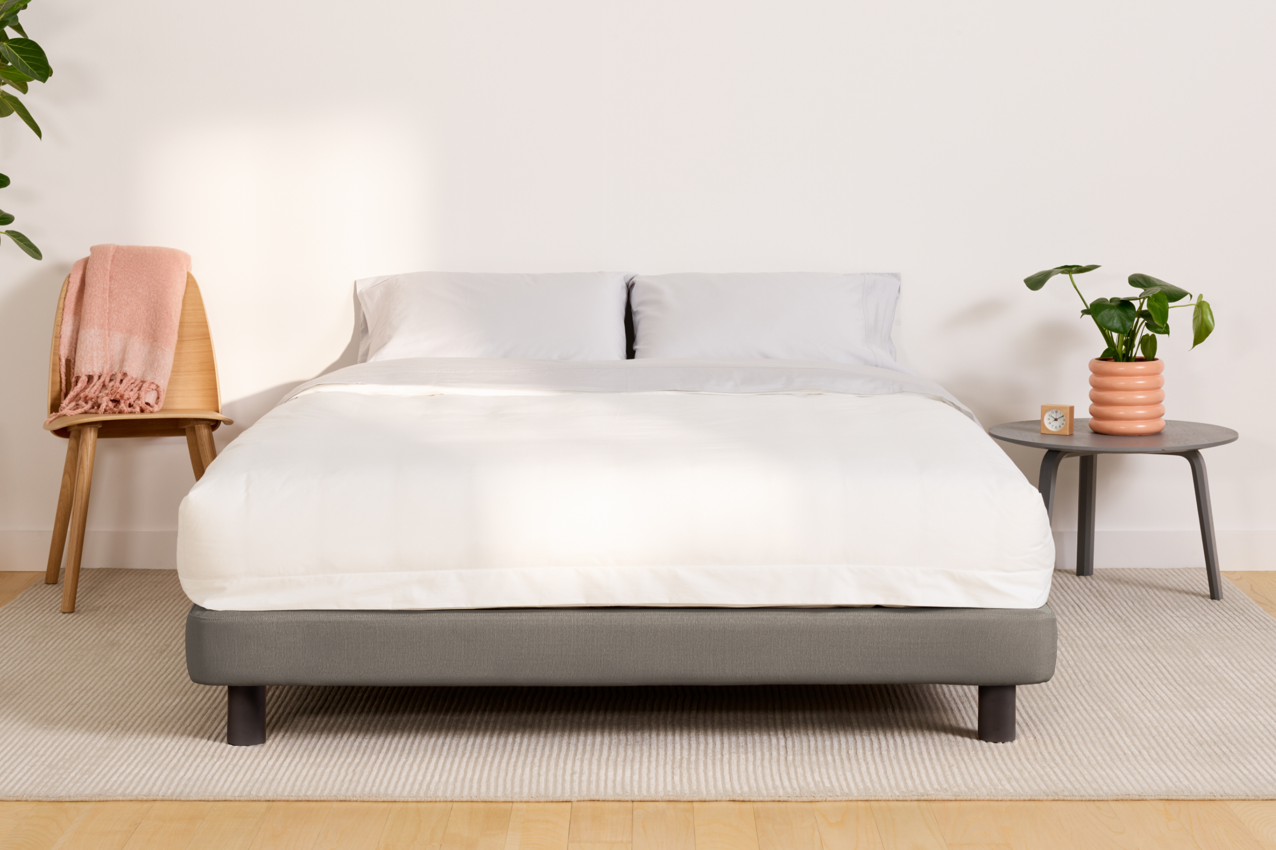 Fully dressed bed on an Upholstered Bed Frame, gray color, in a bedroom setting.