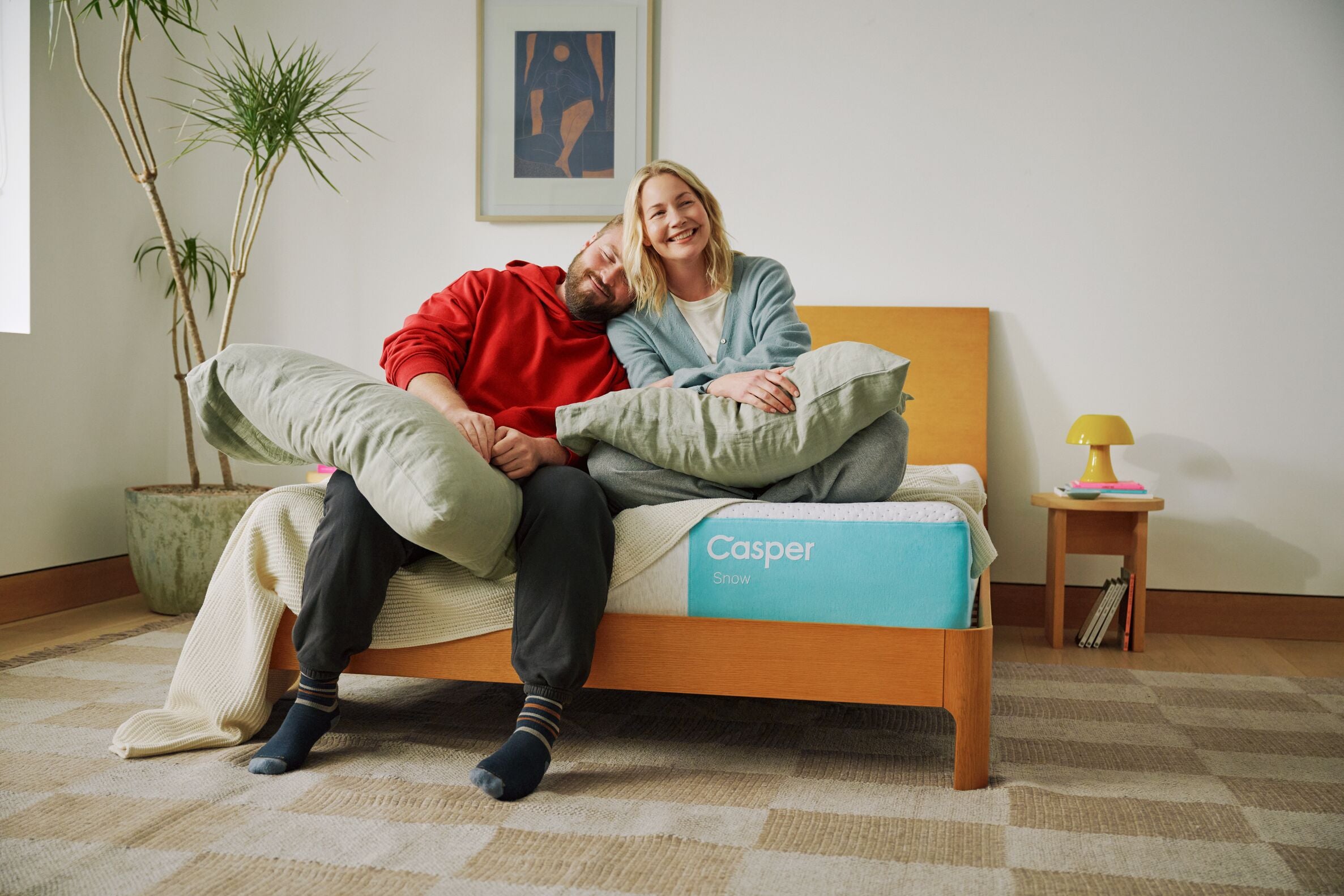 Two people sitting on a Casper snow cooling mattress