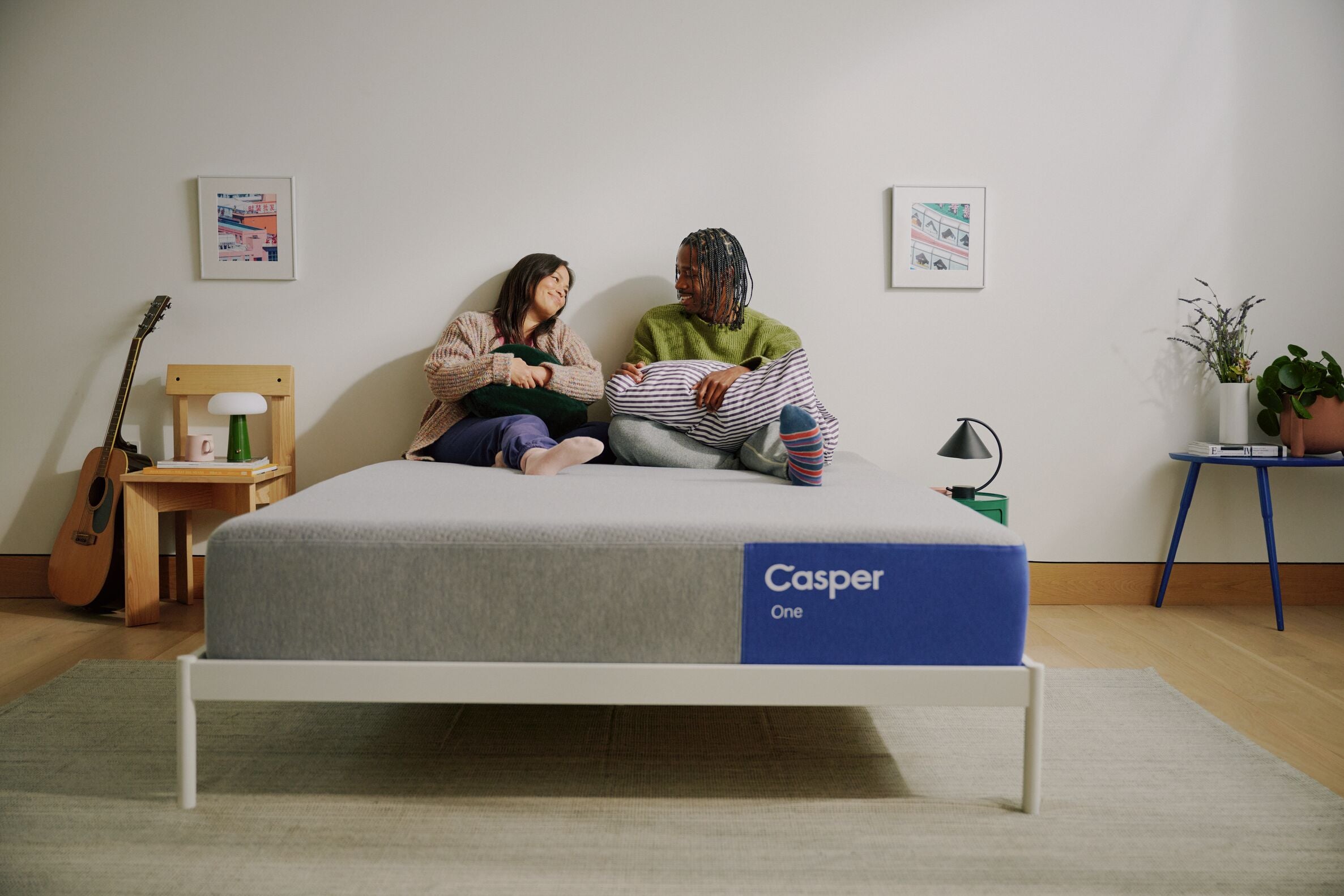 Two people sitting on a Casper One foam mattress