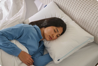 A woman sleeps on her side on a pillow.